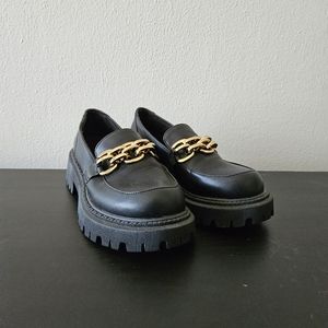Black loafers with gold chain detail